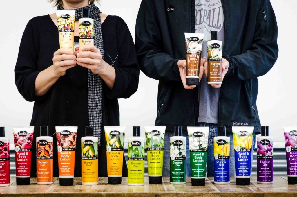 Founders of ShiKai standing in front of a table covered in their products.